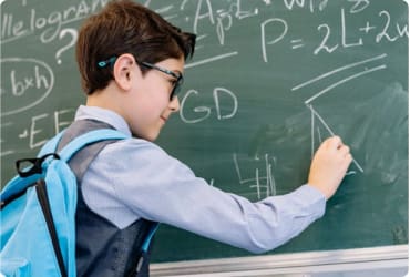 Boy doing math on chalkboard